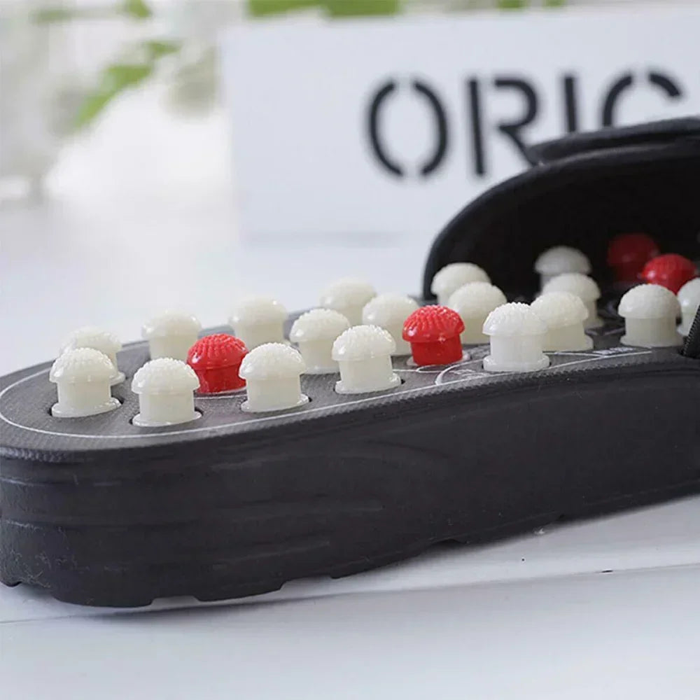 Black Waterproof Acupressure Reflexology Foot Healthy Massage slipper with white and red massage heads on a blurred background