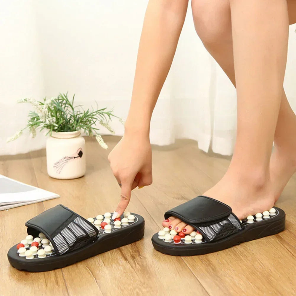 Waterproof Black massage slippers with colorful beads worn by a person on a wooden floor.